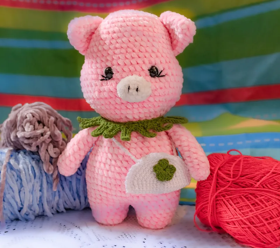Cerdita amigurumi rosada tejida a crochet con collar verde y bolso